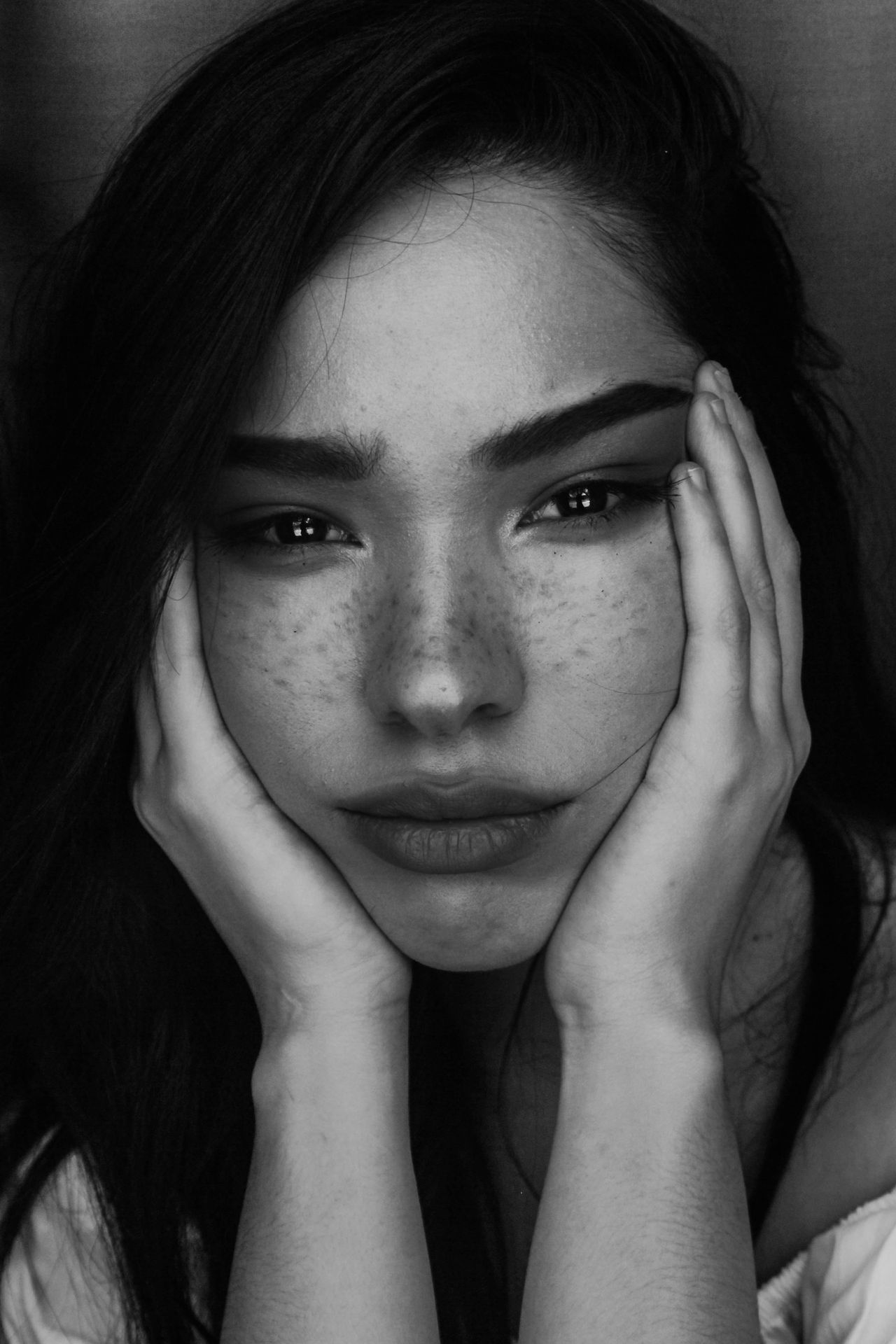 grayscale photography of woman with two hands on her face